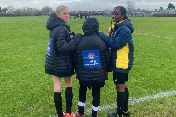 three Stoke Lane AFC girls wearing new coats